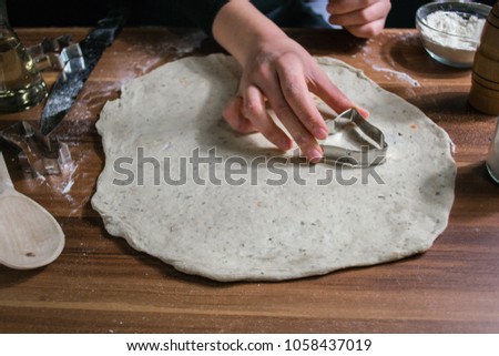 Dough. Work with the test. A woman is cooking cookies. The process of preparing the dough. The girl forms cookies from dough