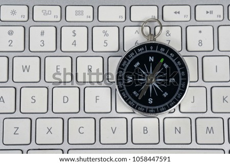 Compass and computer keyboard. Conceptual image.