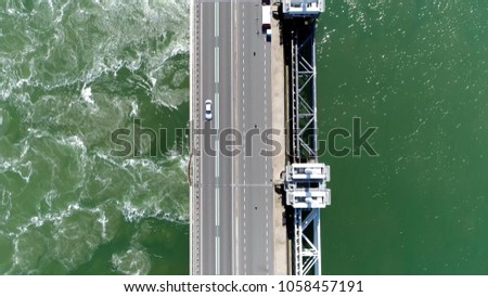 Aerial top down picture Eastern Scheldt storm surge barrier and vehicle driving over road in Dutch Oosterscheldekering the largest of 13 ambitious Delta Works series of dams and storm surge barriers