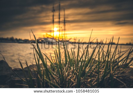 silhouette of historic sailboats on the rivers of the Netherlands. The evening falls in and in an atmospheric summer evening the boats sail over the water surface with sails and masts