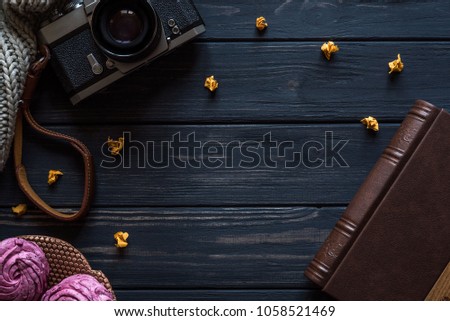 camera, marshmallow and photo album on a black wooden table