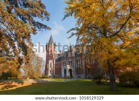 Wonderful Autumn Landscape in Sunny day. Amazing view on Palace in Plawniowice in Autumn. Upper Silesia, Poland. magnificent colorful Trees and Fairytale castle on background. Postcard