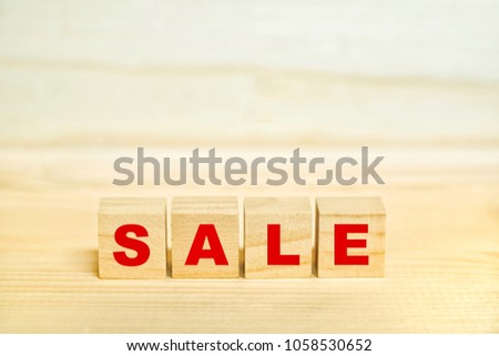 The wooden cube red word "SALE" banner on wooden table background.Business concept.