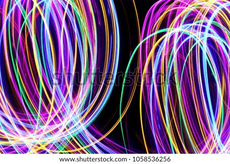 Multi color light painting photography, long exposure swirls and loops of color, against a black background