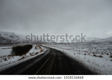 A curvy road in Iceland, leading through a snow covered landscape