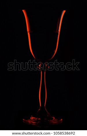 Silhouette beverage glass with drink in bar on black background