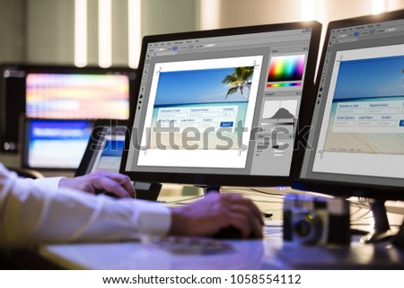 Close-up Of A Designer's Hand Working On Multiple Computer Screen At Workplace