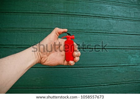 Hand with toy red fire extinguisher