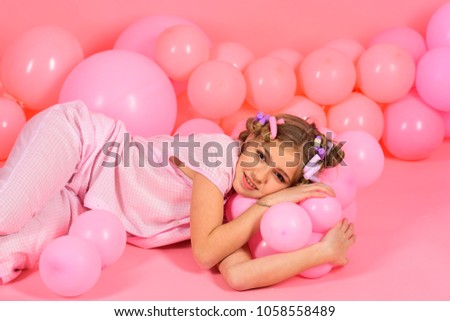 little girl in a pink pajamas plays with balloons. dream and sleep