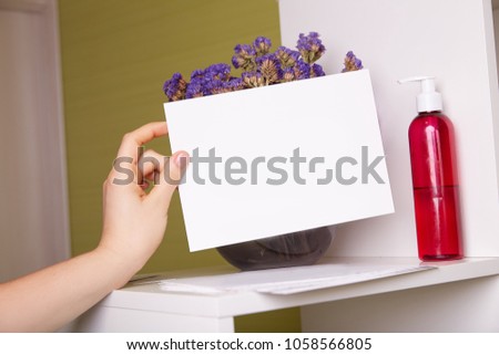 white card on green background and violet flowers
