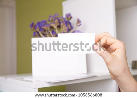 white card on green background and violet flowers