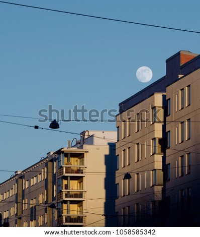 A full moon over the buildings