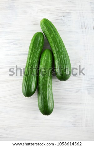 fresh green cucumbers on white wooden kitchen plate, can be used as background