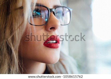Glasses eyewear woman portrait looking away. Close up portrait of female business beautiful student woman model face. Blonde, red lips. Indoor. Royalty-Free Stock Photo #1058615762