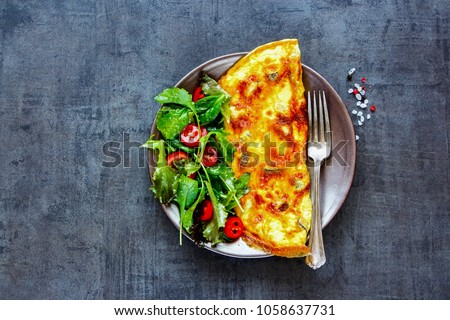 Homemade mushroom omelette with salad on plate over dark concrete copy space background. Healthy food concept. Flat lay, top view Royalty-Free Stock Photo #1058637731