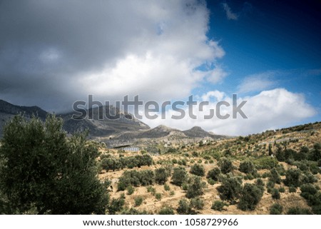 Scenic view of field and mountain against cloudy sky, Crete, Greece