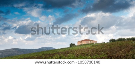 Scenic view of farmhouse on grass field with mountain in background, Crete, Greece