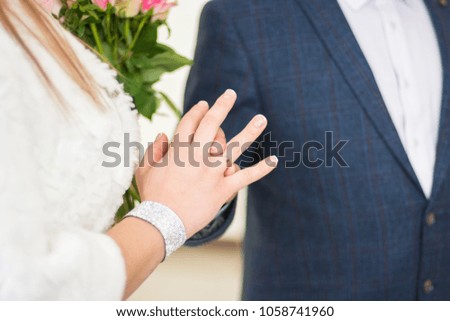 the newlyweds wear each other rings as a sign of eternal love. a beautiful moment of origin of the family. young holding hands