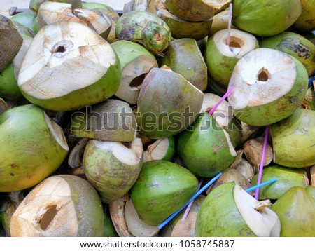 image of used coconut with straws seen in the dustbin or trash. drinking coconut water is good for health during summer season with lot of minerals needed for body kumbakonam thanjavur tamilnadu s
