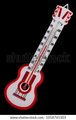 Room thermometer in the form of a guitar isolated on a black background