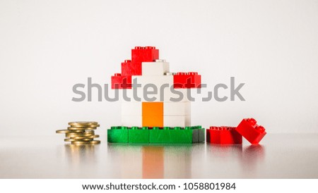 Plastic bricks made and a money coins stack