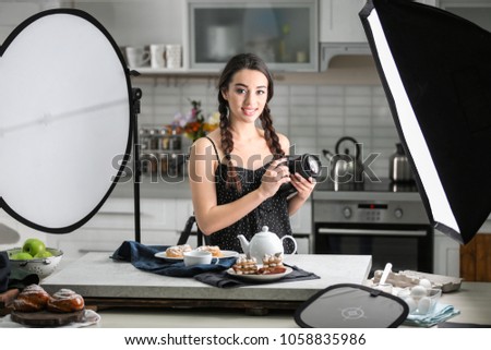 Young woman with professional camera in photo studio