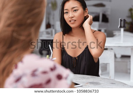Busy Asian female worker meets with business partner in coffee shop, discuss main issues of work and collaboration. Two mixed race students recreat after exam in restaurant, have talk about studying