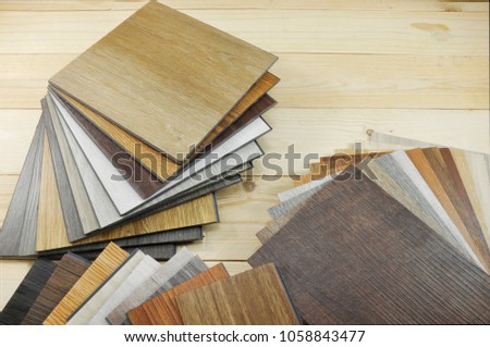 Samples of laminate and vinyl floor tile on wooden Background for new construction or renovate building