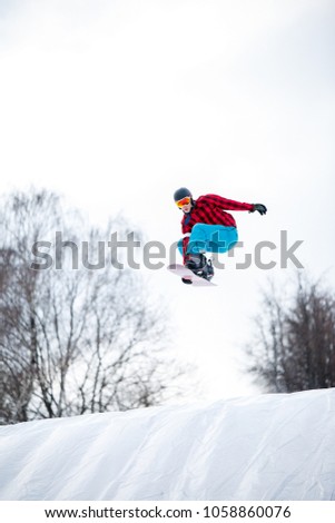 Picture of athlete in helmet riding snowboard from snow slope