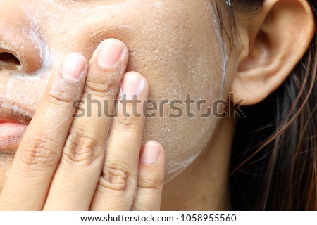 Close up Asia woman cheek. Woman washing face (have wide pores) with white foam by her hand. Royalty-Free Stock Photo #1058955560