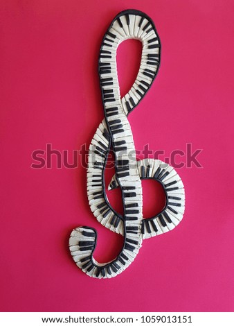 musical symbol made with plasticine, simulating keys on a piano, with red background