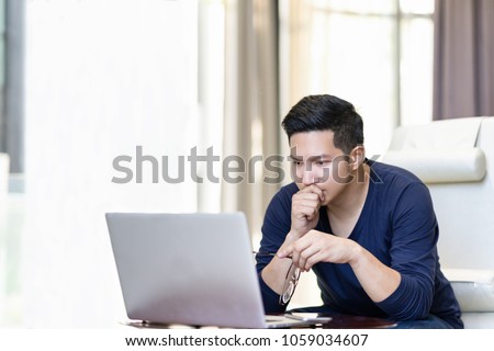 Seriously confident asian young freelancer in smart casual working and concentrated on laptop sitting on desk in modern office ,co-working space or at home with copy space, webinar over the internet Royalty-Free Stock Photo #1059034607