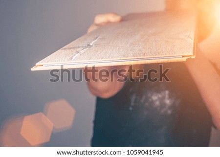 The worker checks the quality of the laminate board, selective focus, blurred background