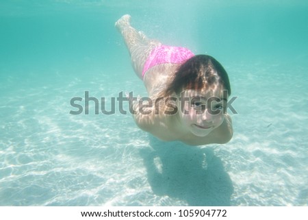 underwater portrait of young happy girl diving