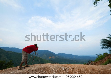 Professional photographer taking a picture of landscape beautiful mountain in rainforest