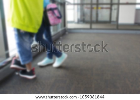 Blurred image of two little sibling boy and girl having fun and going on vacations trip with suitcase at airport, indoors.
