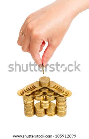 house built of coins female hand isolated on white background