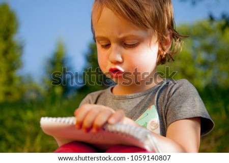 Freelance. Business child girl working outdoors. Humorous picture. (Success, freedom, achievement, wealth concept)