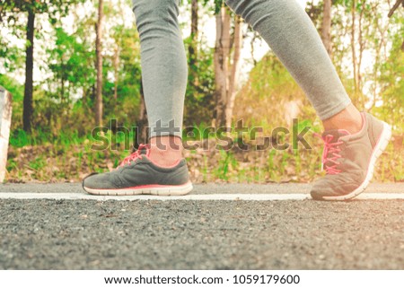 Ready for a sprint. Runner athlete standing on road towards sun. Concept of new start, travel, freedom etc. Close up cropped low angle photo of shoe of athlete.