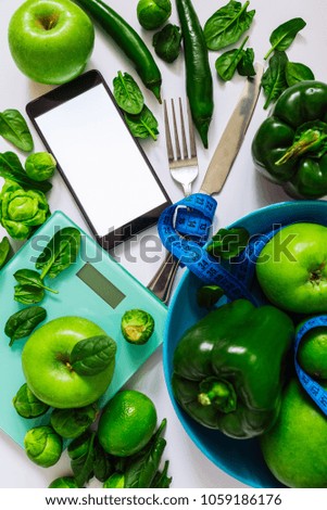 healthy food concept. green food on white background. mobile phone with white screen.