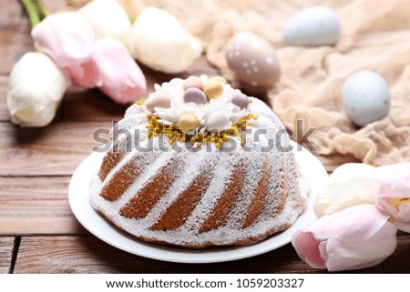 Easter cake with eggs and tulip flowers on wooden table