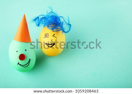 Eggs with funny faces on mint background