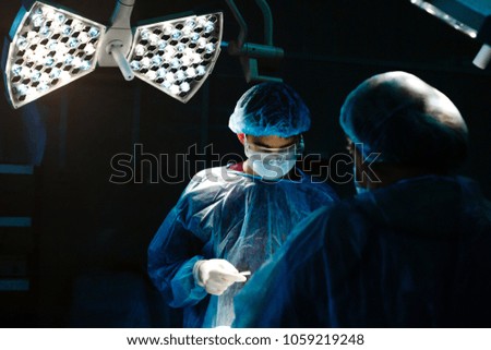 Surgery in the clinic by a group of surgeons under a lamp