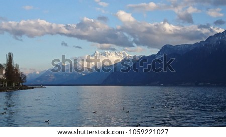 View on distant Les Dents du Midi from Quai Perdonnet in Vevey, Switzerland on a stunning cloudy evening