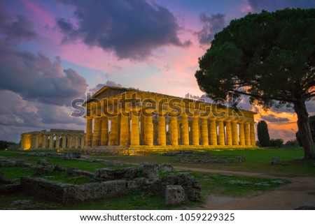 Beautiful sunset in the archaeological  site of Paestum with the temples of Neptune and Hera in the background - Campania, Italy 
