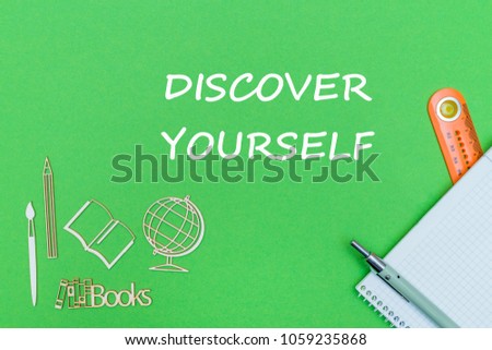 concept school, text discover yourself, school supplies, notebook, ruler, pen on green backboard