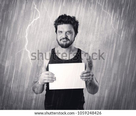 Caught gangster with rainy, grey background and black table on his hand. 