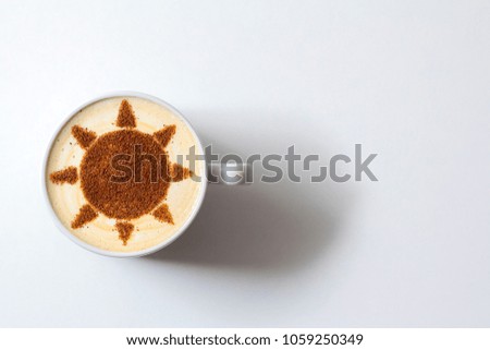 Cappuccino in a white cup with a picture of the sun on milk foam