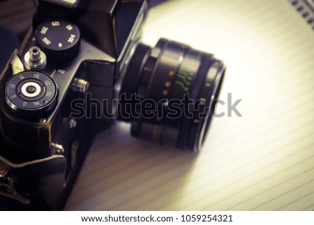 Vintage film camera in a leather case on wood background