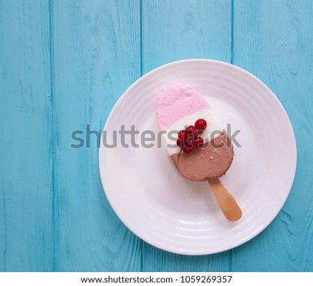 ice cream with red currant on blue wooden